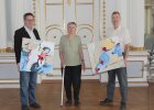 Regierungsvizepräsident Florian Luderschmid präsentiert mit Rose Karrer-Bäuerle und ihrem Sohn zwei Werke der Künstlerin