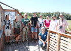 Die Biodiversitätskoordinatorinnen und -koordinatoren der Regierungen stehen vor einem Fernrohr zur Vogelbeobachtung für ein Gruppenfoto