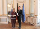 Regierungsvizepräsident zeigt zusammen mit Dr. Magdalena Helmig das Bundesverdienstkreuz mit zugehöriger Urkunde
